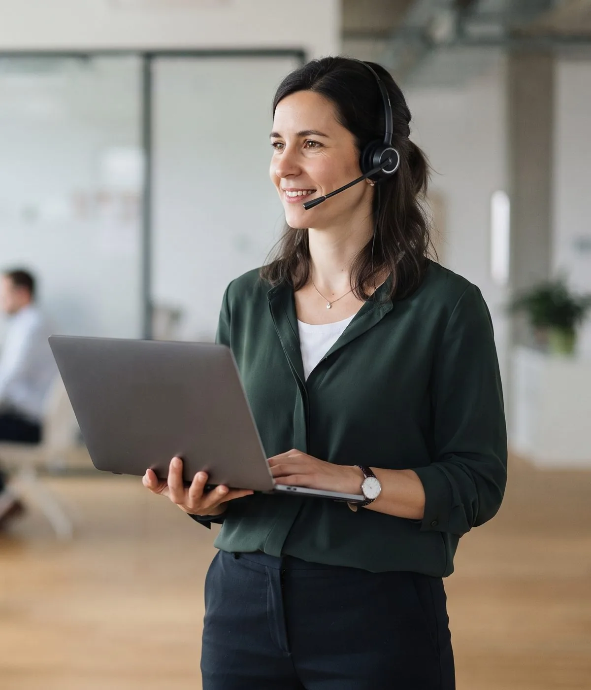 Dolmetscherin mit Headset und aufgeklapptem Notebook in einem hellen Büro
